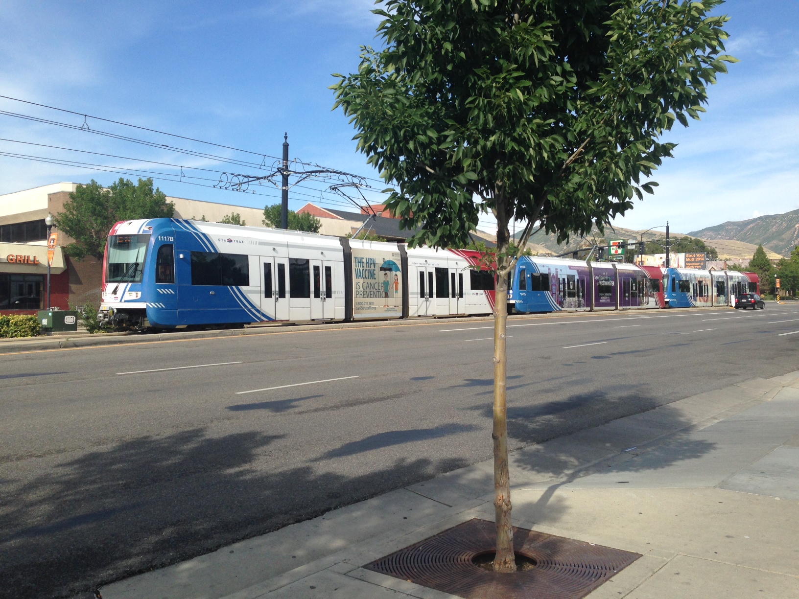 A UTA TRAX train moves towards the University of Utah on University Blvd.